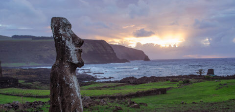 Die Osterinsel zu Sonnenuntergang am Ozean mit Bergen und Moai Statue