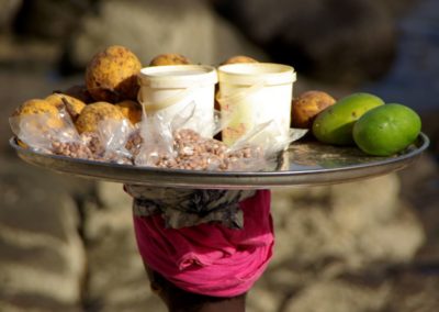 Afrikanerin mit Früchten und Nüssen am Kopf