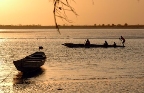 kleine Holzboote auf einem Fluss Westafrikas bei Sonnenuntergang