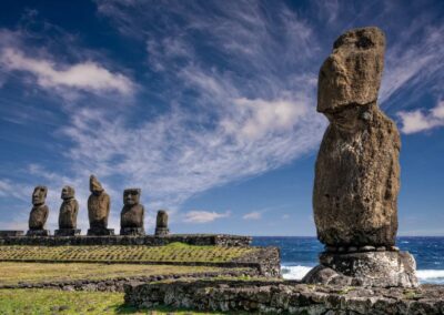 Large moai statue in the foreground in front of an ahu ceremonial platform with four moai sculptures on Easter Island.