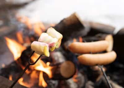 Marshmallows und Würstchen am Lagerfeuer im Aurora Village.