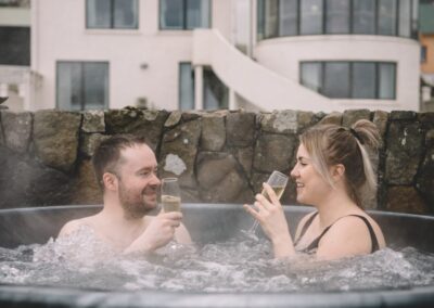 Außenansicht Hotel im Vordergrund zwei Personen in einem Whirlpool