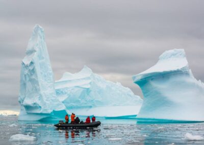 Zodiac with passengers among towering icebergs
