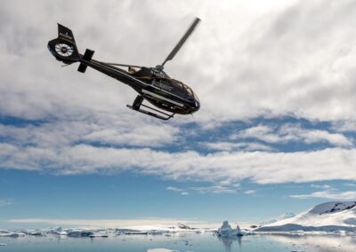 Ein Helikopter über antarktischer Landschaft