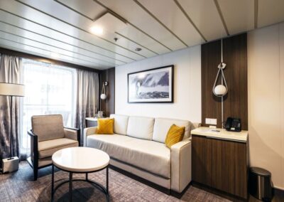 Lounge der Junior Suite mit Couch, Tisch und TV