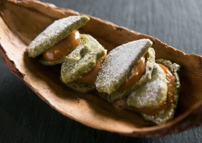 Pastry dusted with powdered sugar and filled, served in a wooden bowl