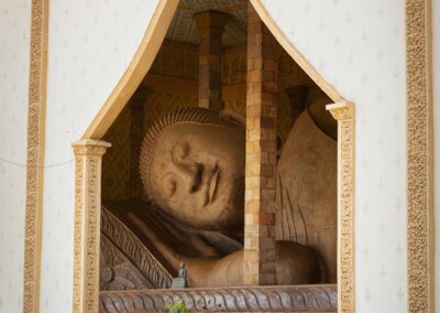 Statue eines liegenden Buddhas hinter einem Türeingang