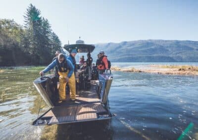 Menschen auf einem Beiboot, das zum Aussteigen hinten geöffnet ist.