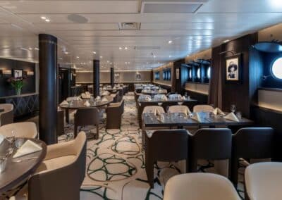 Ein Speisesaal mit eingedeckten Tischen in eleganten Brauntönen