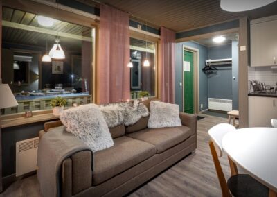 Wohnbereich eines Chalets mit gemütlicher Sitzgelegenheit und großen Fenstern