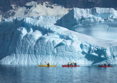 Three kayaks off a glaciated coast in Antarctica