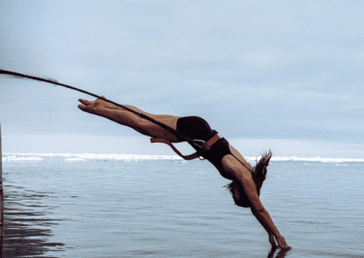 A woman jumps headfirst into the sea.