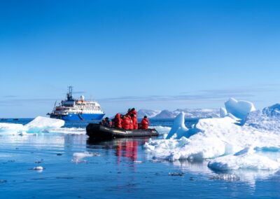 Zodiac vor der MS Sea Spirit zwischen Eisbergen in einem Fjord Spitzbergens