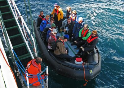 Expeditionsgäste kehren mit dem Zodiac von einem Landgang zum Schiff zurück