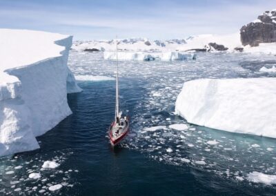 Yacht zwischen Eisbergen aus der Vogelperspektive