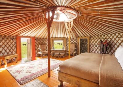 Schlafbereich einer Gäste-Ger der Three Camel Lodge mit Doppelbett, Holzboden und Teppich