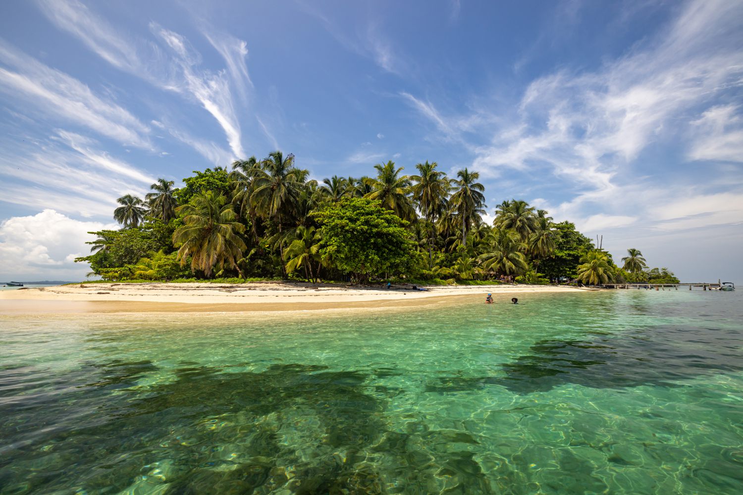 Palmenbewachsene Insel mit weißem Sandstrand im türkisen Wasser
