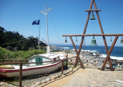 A boat and bells in front of Pablo Neruda's house in Isla Negra on the Pacific Ocean