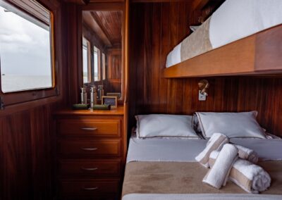 Amazon Dolphin connecting cabin with a window overlooking the river and a bunk bed