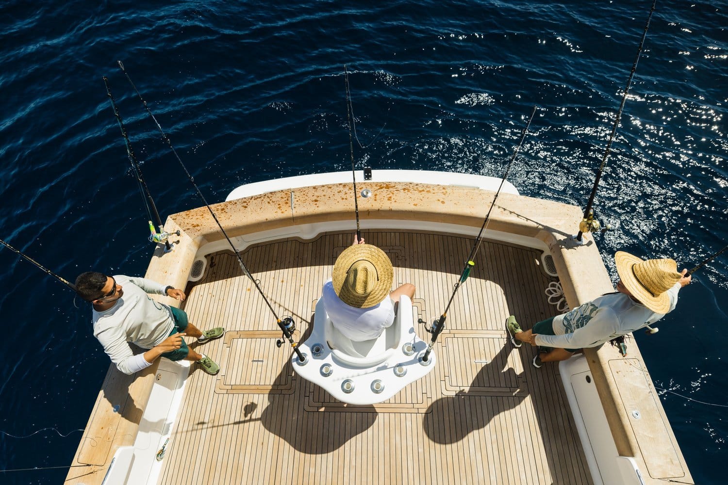 Fishing boat with anglers at the stern, seen from above