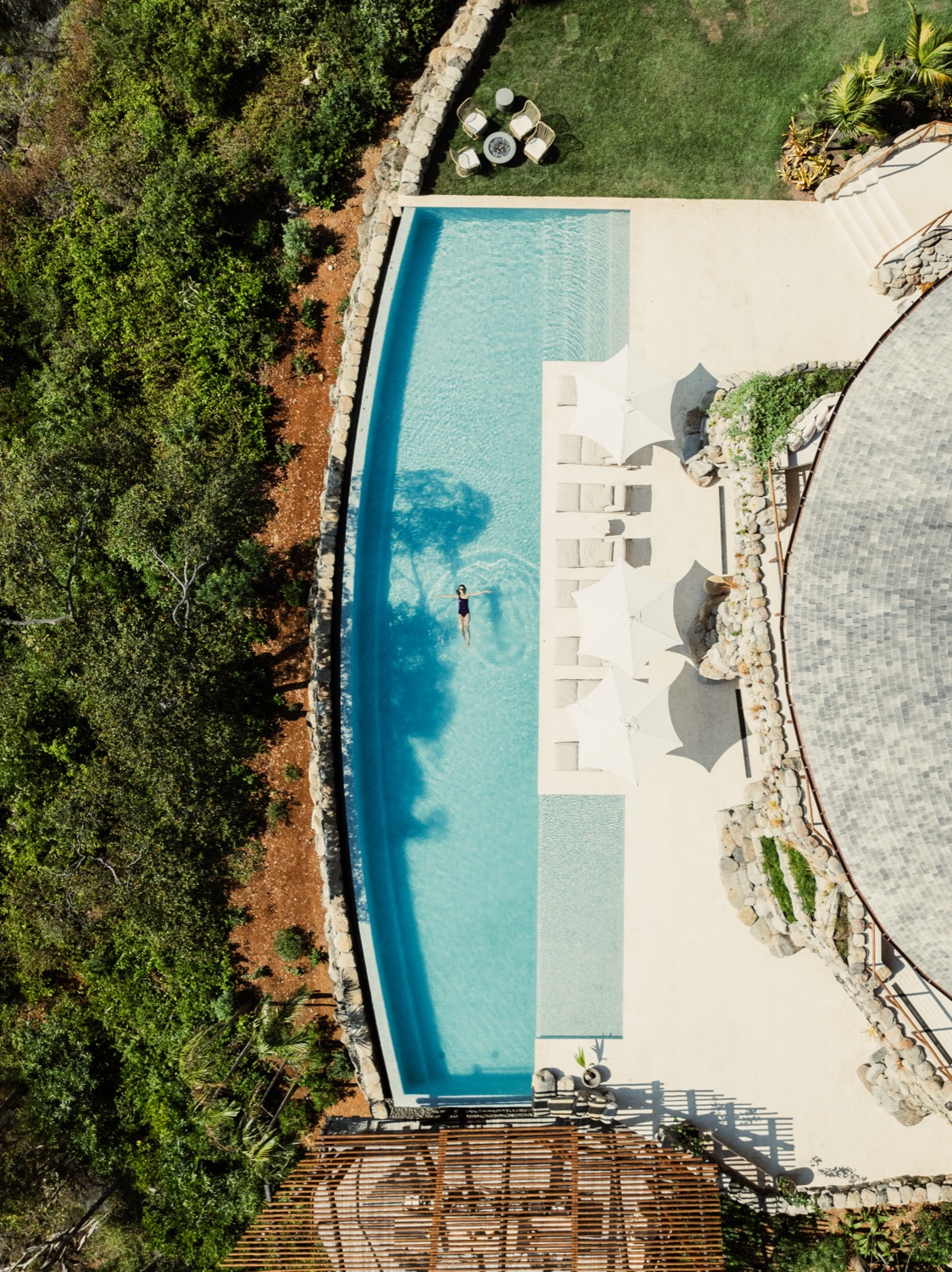A bird's-eye view of Casa Cavada's semi-Olympic infinity pool with sun loungers