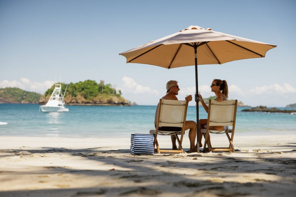 Picknick unter dem Sonnenschirm an einem einsamen Strand