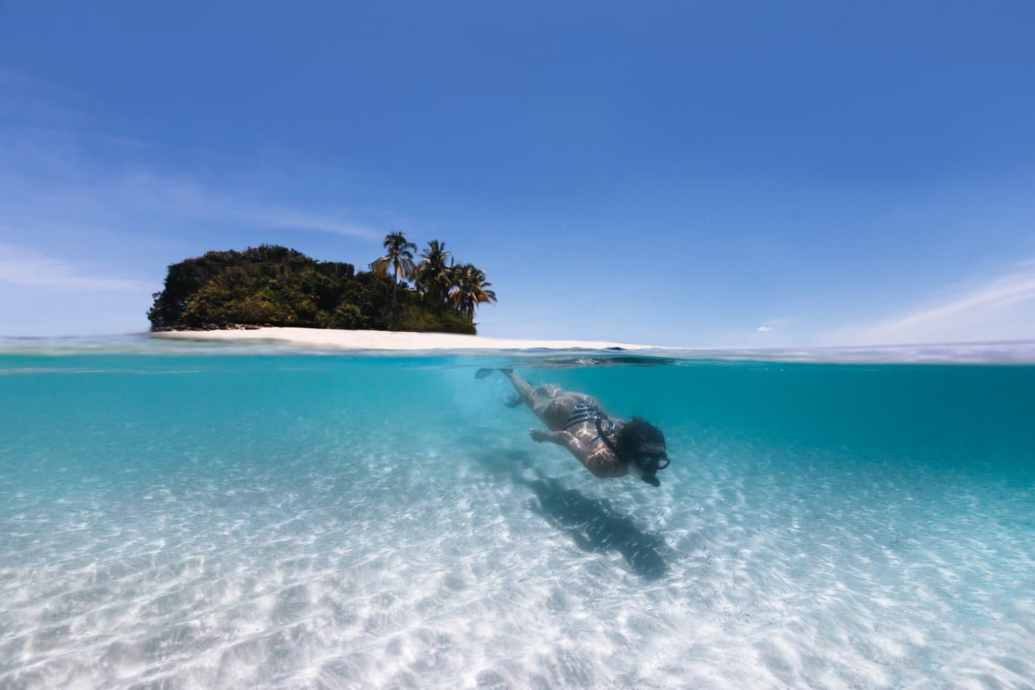 Schnorcheln im klaren Wasser A swimmer underwater in the clear sea off a small island