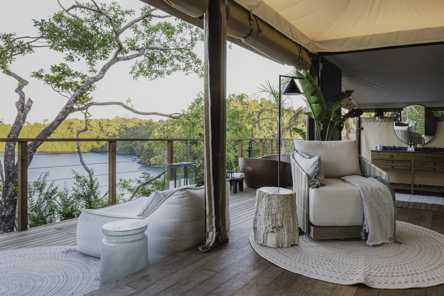 Armchairs and daybeds on the terrace of a Tented Casita overlooking the bay