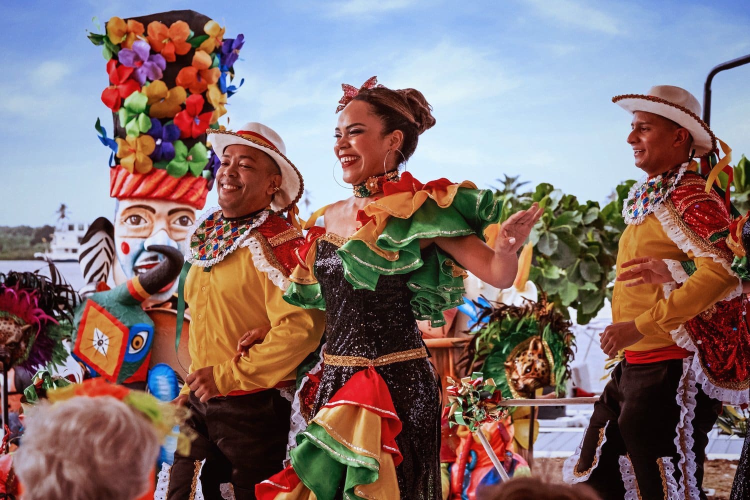Tanz in den Trachten des Carnaval Dancers in traditional costumes in front of Carnival figures on the riverbank
