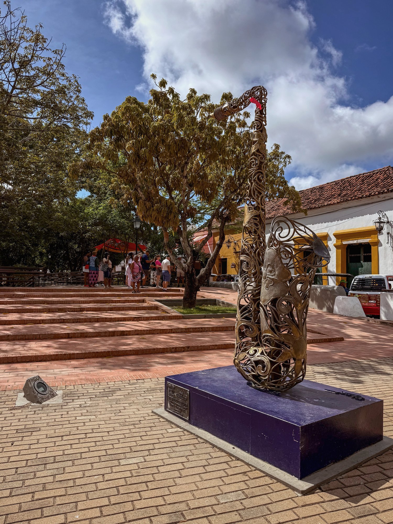 Ein geschmiedetes Saxophon als Denkmal der Musik An artfully forged saxophone sculpture in a square lined with colonial-style houses