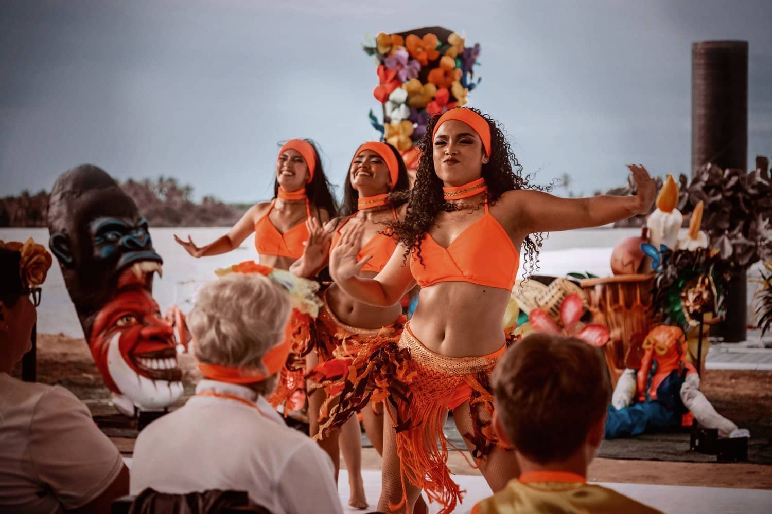 Tänzerinnen bei der Carnaval-Feier Three female dancers in orange costumes in front of an audience
