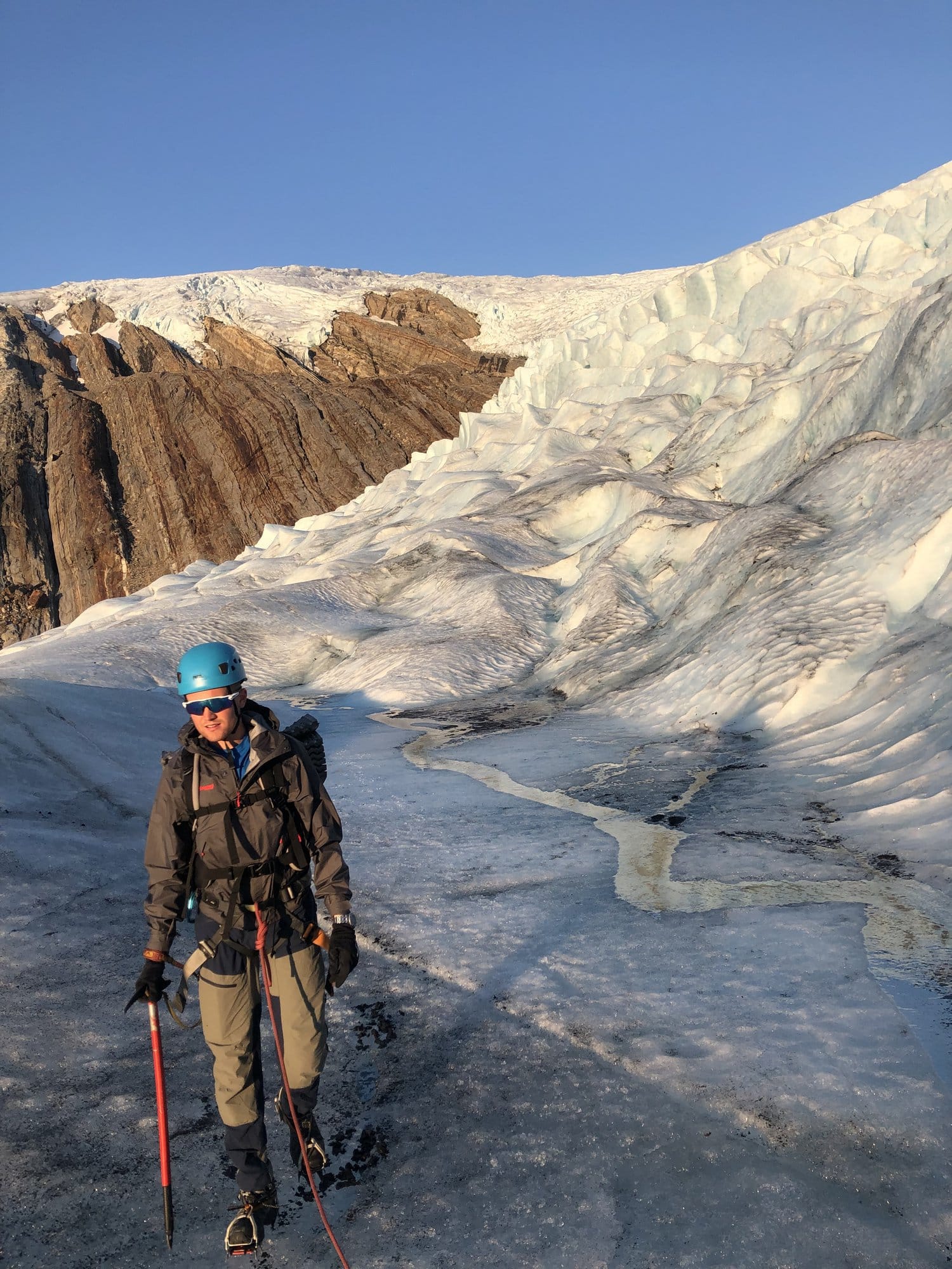 Person mit Helm und Eisgerät steht auf der weiten Eisfläche des Svartisen-Gletschers