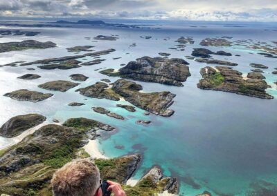 Fotograf blickt von einer Anhöhe über türkisfarbenes Wasser und weiße Sandstrände der Schären