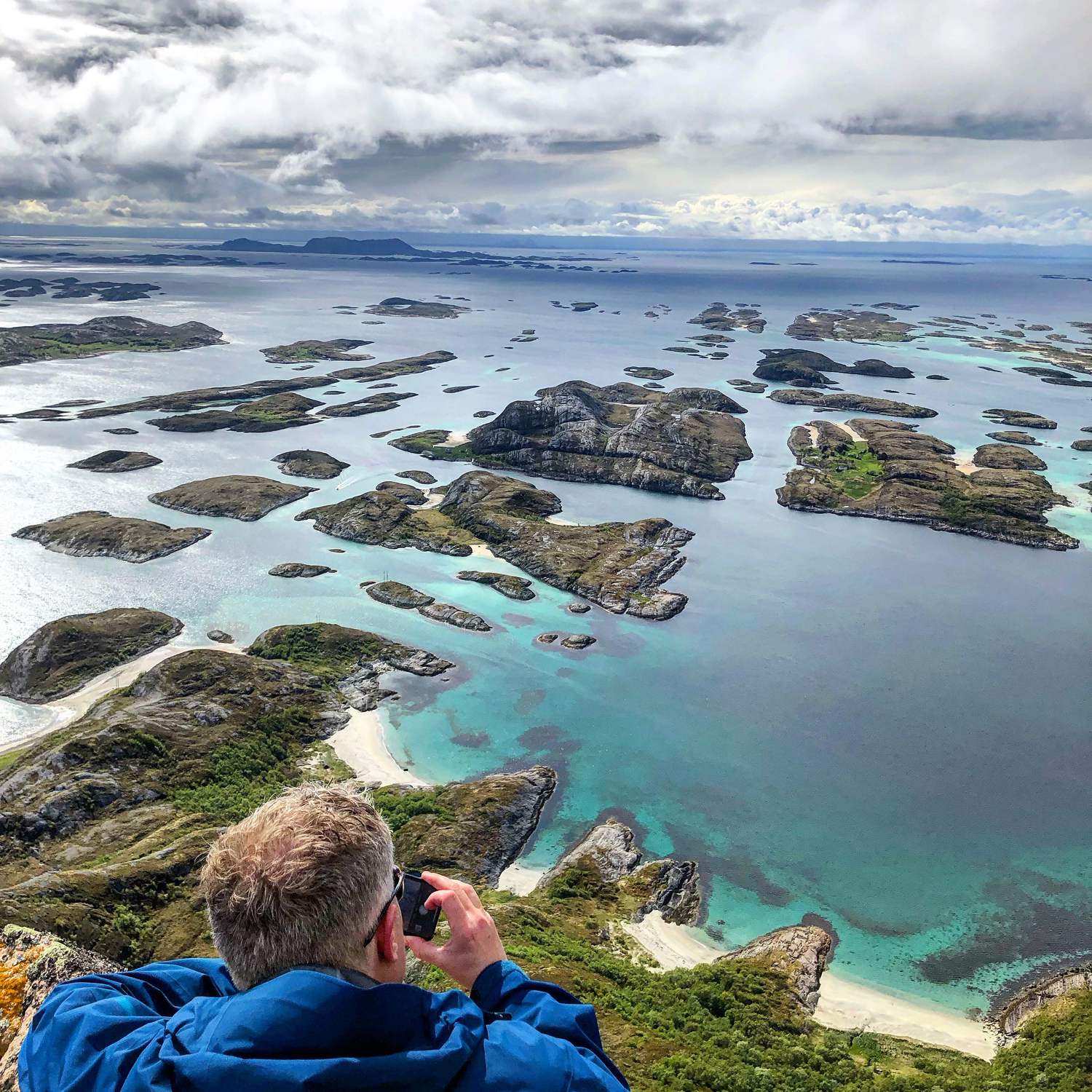 Fotograf blickt von einer Anhöhe über türkisfarbenes Wasser und weiße Sandstrände der Schären