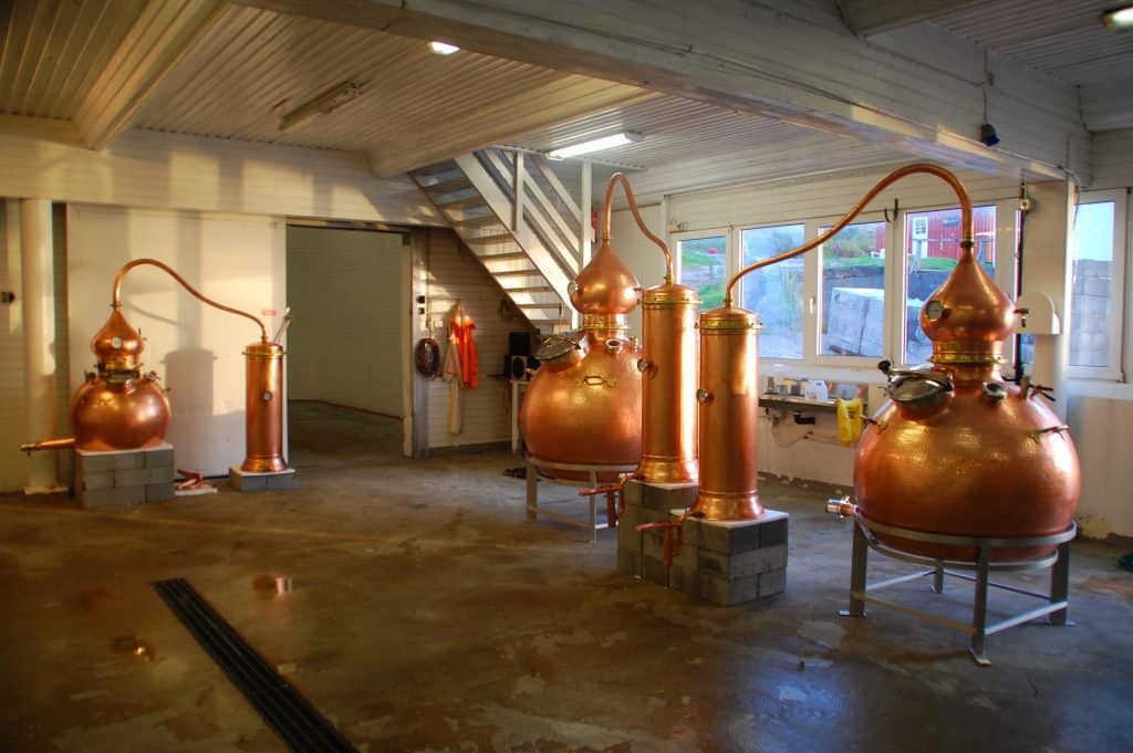 Vier kupferne Brennblasen im hellen Destillerieraum der Whiskybrennerei auf Myken