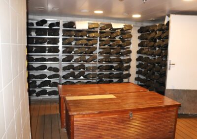 Mudroom der MS Discoverer mit Regalen voller Gummistiefel und Holzbänken