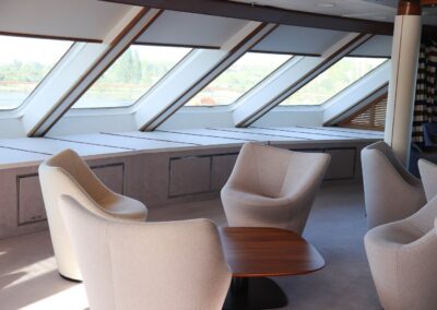 Aussichtslounge der MS Discoverer mit schrägen Panoramafenstern und Sesseln