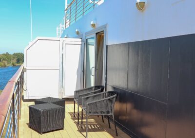 Privatbalkon der Owner's Suite der MS Discoverer mit Sitzmöbeln auf Holzdeck