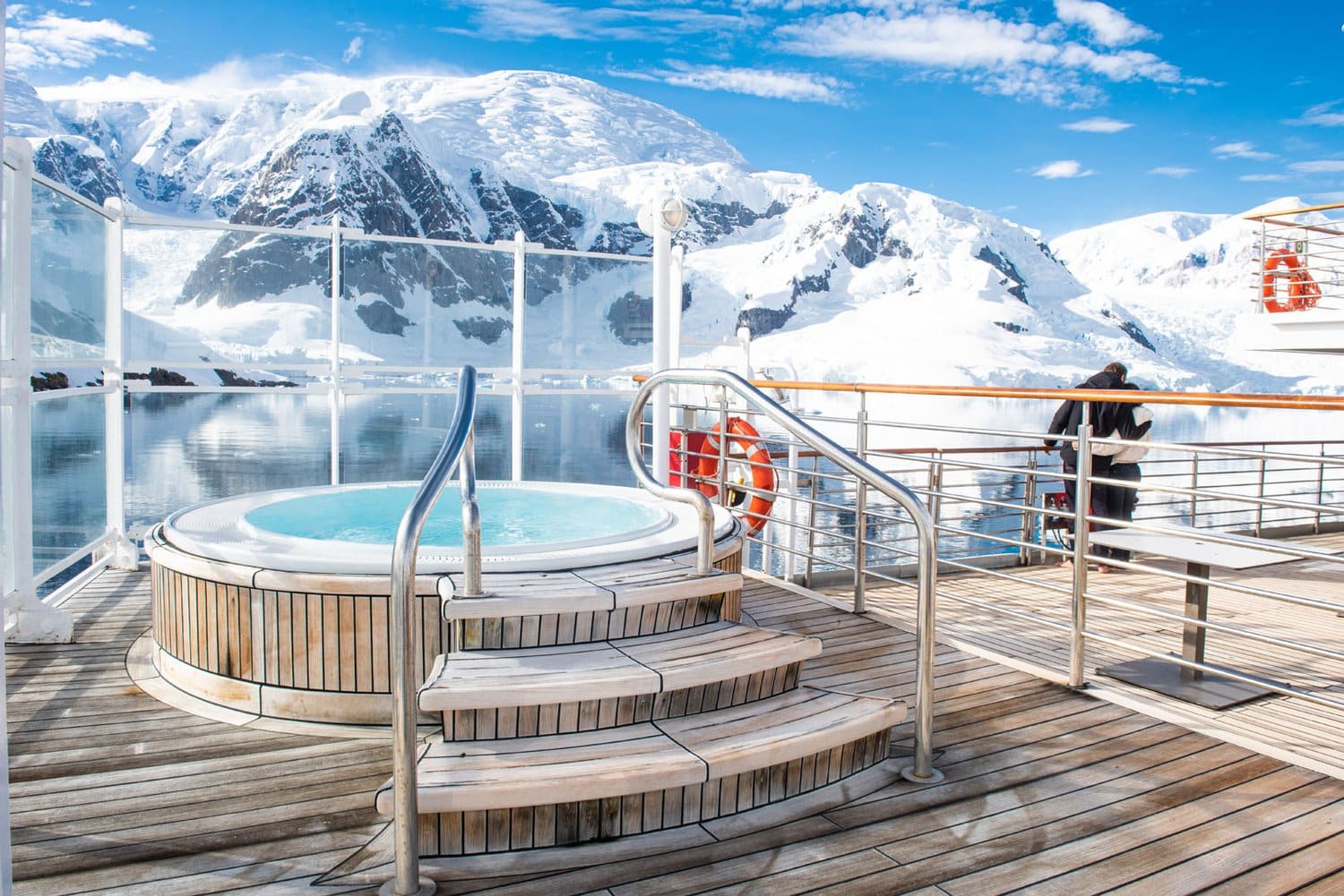 Der Whirlpool auf Deck 6 mit Blick auf verschneite Berge Außen-Whirlpool auf Deck 6 der MS Heritage Discoverer mit Holztreppe, dahinter verschneite Berge
