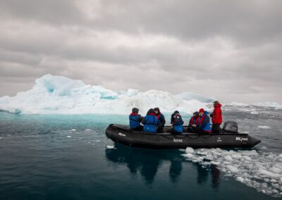 Zodiac with passengers navigating between ice floes off Ilulissat