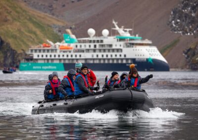 The Zodiac with passengers in front of the Sylvia Earle in Godthul Bay, South Georgia